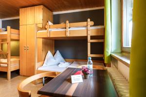 克罗伊特克罗伊特特格尔恩旅舍的客房设有一张桌子和一张双层床。