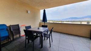Grosseto-PrugnaLoCorse - Superbe appartement T2 avec une belle vue mer的用餐室配有桌椅和遮阳伞