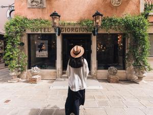 威尼斯乔尔乔涅酒店的站在商店前戴帽子的女人
