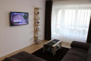 康斯坦察CityApart GranVia Marina - Cazare în Constanța, lângă stațiunea Mamaia的客厅配有沙发和墙上的电视