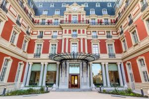 比亚里茨Hôtel du Palais Biarritz, in The Unbound Collection by Hyatt的一座建筑的顶部有钟