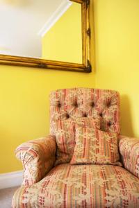 拉姆斯盖特拉姆斯盖特福斯塔夫餐厅酒店的一张沙发,坐在一个带镜子的房间