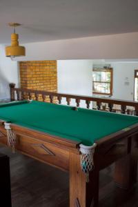 贝洛奥里藏特Pousada Lagoa的带壁炉的客房内的绿色台球桌