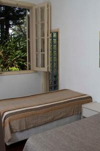 贝洛奥里藏特Pousada Lagoa的一张位于带窗户的房间的床