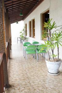 贝洛奥里藏特Pousada Lagoa的庭院设有绿色桌椅和植物