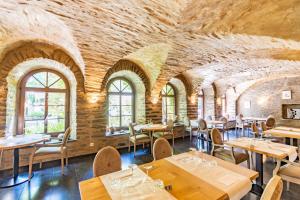 维尔茨Aux Tanneries de Wiltz的一间带桌椅的餐厅以及砖墙