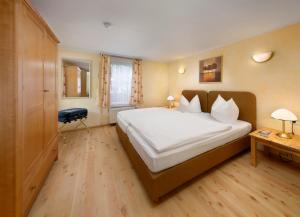 莱比锡KNAUS Campingpark Leipzig的卧室配有一张白色大床和一张书桌