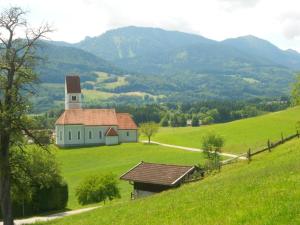 弗拉斯多夫Lenzenhof, Familie Christian und Stefanie Spitzl的一座白色的教堂,位于绿地中,有一座小山