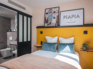 巴黎Hôtel Piapia的一间卧室配有一张带黄色床头板的大床