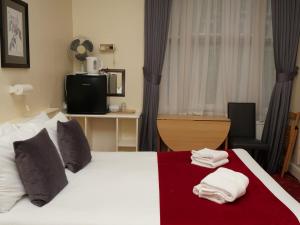 伦敦阿兰大楼酒店的酒店客房,配有带毛巾的床
