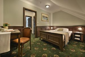 伏尔塔瓦河畔赫卢博卡波德拉德酒店的一间卧室配有一张床、一张桌子和一张书桌