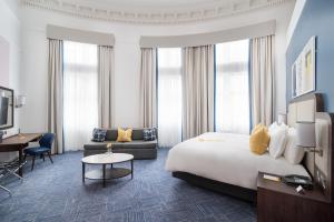 格拉斯哥voco Grand Central Glasgow, an IHG Hotel的酒店客房配有一张特大号床和一张书桌