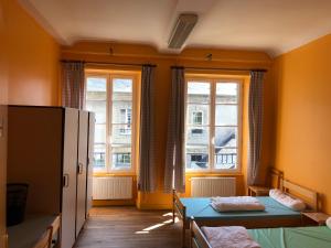 贝叶Hostellerie des Grands Chapeaux的小房间设有两张床和两个窗户