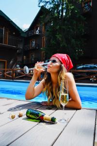 布克维吉马斯诺滑雪温泉公寓酒店的游泳池旁喝一杯葡萄酒的女人