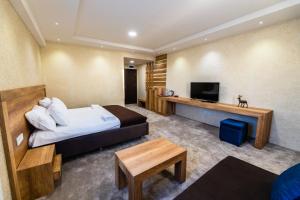 科查尼Magnolija Resort Ponikva的配有一张床和一台平面电视的酒店客房