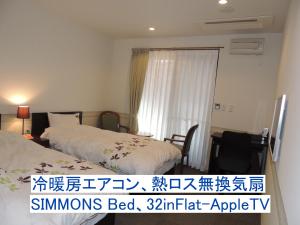 轻井泽海奇安住宿加早餐酒店的酒店客房设有两张床和窗户。