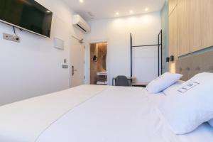 马拉加Real Maqueda - Málaga的卧室配有一张白色大床和一张书桌