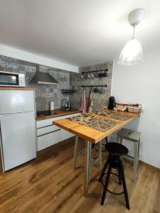 阿尔苏阿Casa Luis的厨房配有木桌和白色冰箱。