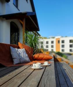 JaraczHotel Odpocznia Resort i Las的一张木桌上的沙发,上面有两杯咖啡