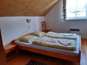 PoráčChalupa Helena na Poráči的卧室内的一张床铺,设有木制天花板