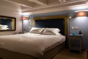 姆迪纳克拉皇宮城堡酒店的卧室配有一张白色大床和镜子