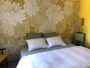 维列莫尔贡La Gatille的一间卧室配有一张带花卉壁纸的床