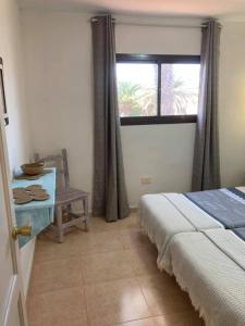 科拉雷侯Casa Camar的一间卧室设有一张床、一个窗口和一把椅子