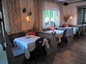 滨湖采尔玛格丽特旅馆的餐厅设有四张桌子和椅子以及窗户