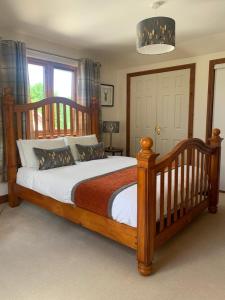 奥本Inverasdale的一间卧室配有一张大木床和白色床单