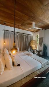 Santa MonicaKaha Island Stay的卧室配有一张白色大床和木制天花板