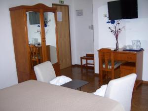 布拉干萨圣塔阿波洛尼娅酒店的配有桌椅和电视的客房
