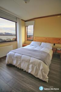 纳塔列斯港萨尔托斯德尔潘恩酒店的卧室设有一张大床,设有两个窗户