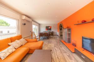 莱斯卡拉Villa Eugenia的橙色的客厅配有沙发和电视