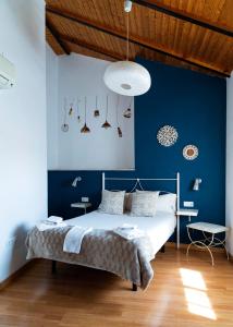 乌贝达Apartamentos Turísticos Architettura Úbeda的一间卧室配有一张蓝色墙壁的床