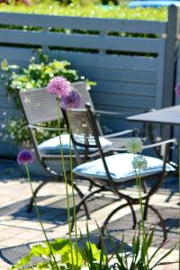 霍瓦赫特Kleines Landleben的一张椅子,坐在桌子旁,花紫色