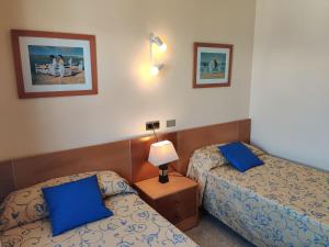 阿尔库迪亚港Mar Blau的两张位于酒店客房的床,配有蓝色枕头