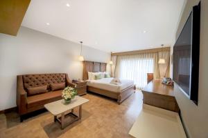 维杰亚瓦达Jade Suites - Luxury Boutique Hotel的客厅配有沙发和1张床