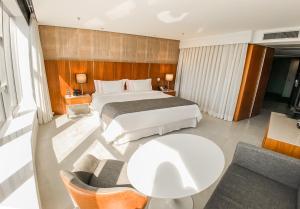 里约热内卢Hotel Nacional Rio de Janeiro - OFICIAL的酒店客房配有一张床铺和一张桌子。