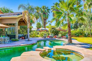 兰乔米拉日Indulgent Escape In Rancho Mirage的棕榈树庭院内的游泳池