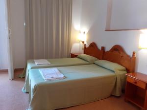 卡里拉Apartaments Mar Blau Calella的配有2盏灯的酒店客房的2张床