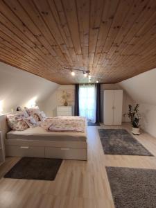 Pichling bei StainzPension Treissmann的一间卧室设有一张带木制天花板的大床