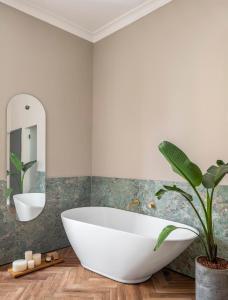 耶路撒冷Hotel Noel Jerusalem的浴室配有大型白色浴缸和植物