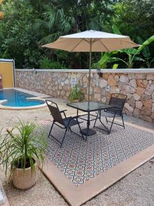 伊萨马尔Nicol-Haa的游泳池旁配有遮阳伞的桌椅