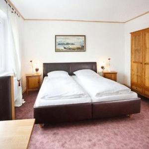 Oberopfingen狮子乡村宾馆的卧室内的一张大床,带两个床头柜