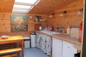 迪斯Green Rabbit Glamping的厨房设有木墙和带水槽的台面。