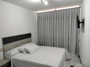 穆罗斯A Casa de Lolita的卧室配有白色的床和窗户。