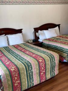 弗洛伦斯西别墅汽车旅馆的两张睡床彼此相邻,位于一个房间里