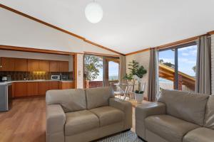 林肯港The Flaxman Studio - Panoramic Ocean Views的一间带两张沙发的客厅和一间厨房