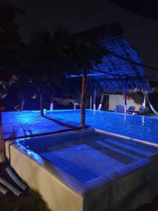 EscuintlaMi Casa en la Playa的夜间拥有蓝色灯光的游泳池