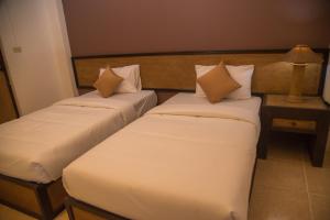 清迈Sleep CNX的配有枕头的酒店客房内的两张床